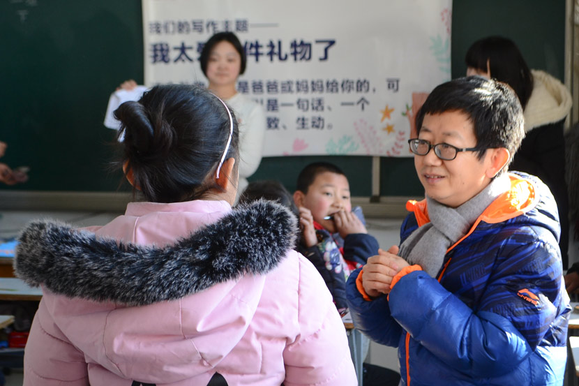 Guan Jun talks to a student during class at Minren Primary School in Beijing, Dec. 13, 2018. Fan Liya/Sixth Tone