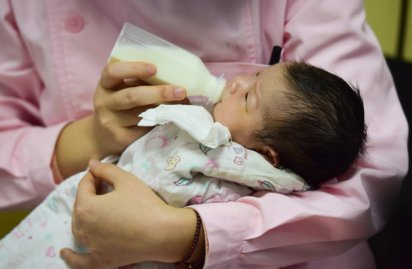 A nurse feeds a newborn at a hospital in Fuyang, Anhui province, Jan. 19, 2019. Lu Qijian/VCG