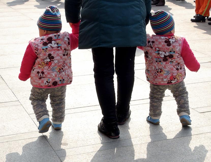 A parent holds hands with their two children in Nanjing, Jiangsu province, March 5, 2014. An Xin/VCG