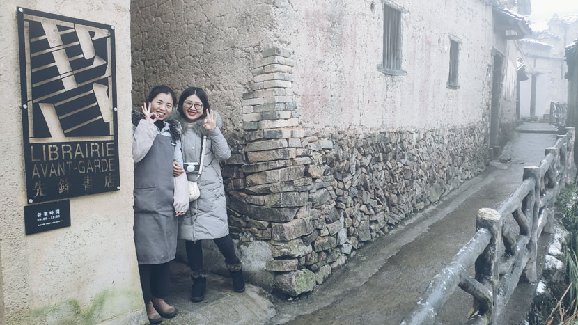 Li Xia, the store manager (left), and a reader pose for a photo next to Chenjiapu Bookstore in Songyang County, Zhejiang province, Jan. 2, 2019. Fan Yiying/Sixth Tone