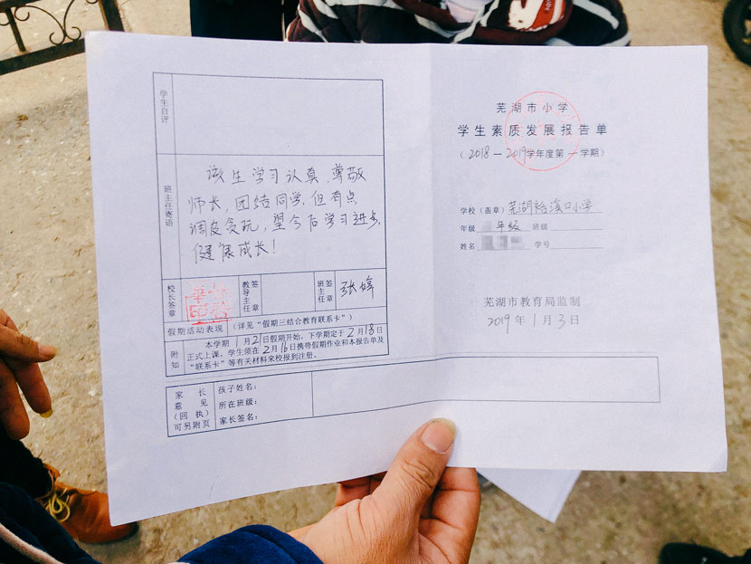 A parent shows his child’s school report in Wuhu City, Anhui province, Jan. 20, 2019. Fu Danni/Sixth Tone