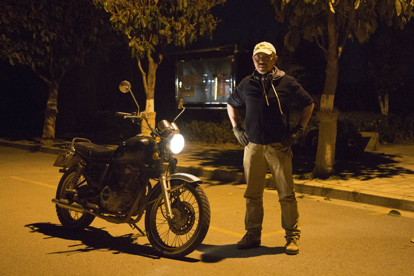 Xu Song poses for a photo with his motorbike in Dali, Yunnan province, March 16, 2019. Shi Yangkun/Sixth Tone