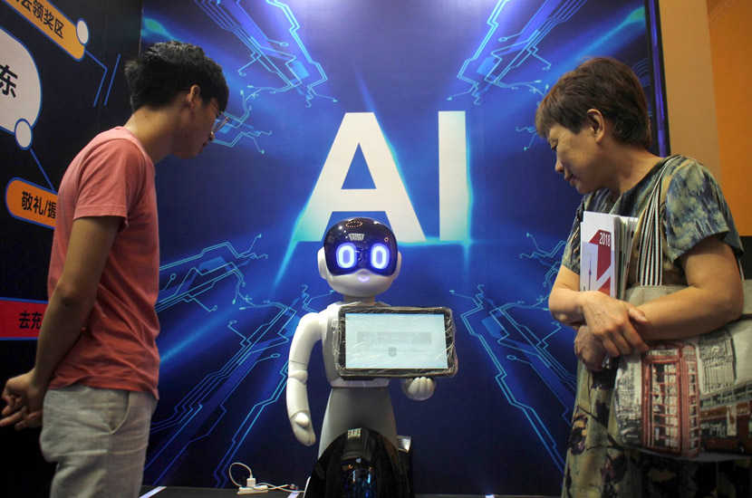 Visitors examine a robot during a popular science product expo in Shanghai, Aug. 27, 2018. Xing Yun/VCG