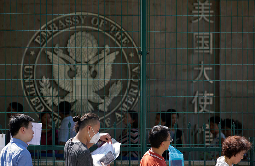 Visa applicants wait to enter the U.S. Embassy in Beijing, July 26, 2018. Ng Han Guan/IC
