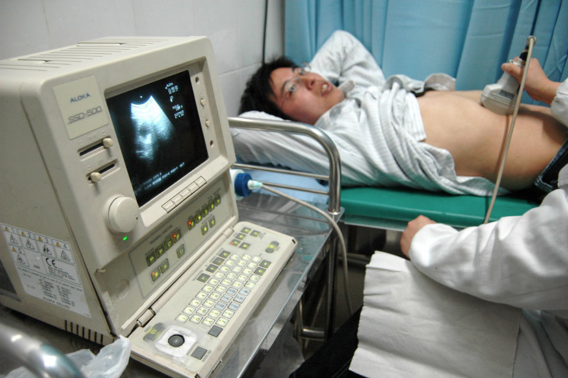A medical staff member uses an ultrasound on a patient in Huai’an, Jiangsu province. Xu Changzheng/VCG