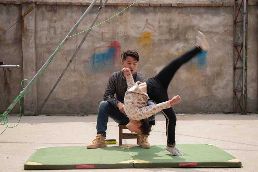 Li Xiaogao watches a girl practice her tumbling in Bozhou, Anhui province, March 23, 2019. Kenrick Davis/Sixth Tone