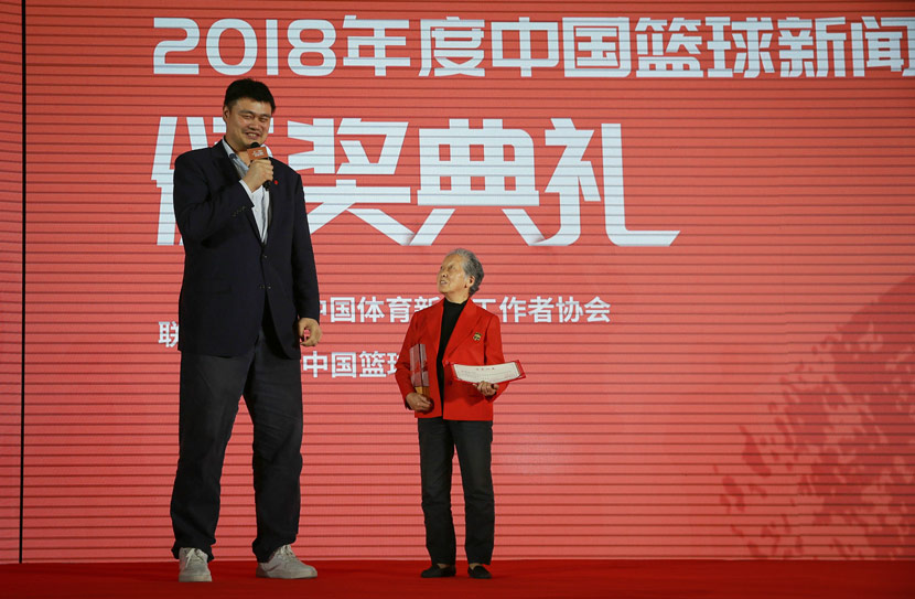 Yao Ming (left) speaks as 81-year-old sports photographer Hong Nanli (right) receives a special award for her basketball reporting contributions during the China Basketball News Award ceremony in Beijing, April 24, 2019. IC