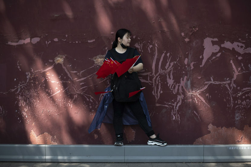 A woman sells national flags near Tiananmen Square as people gather to mark May Day, also known as Labour Day, in Beijing, May 1, 2019. Fred Dufour/AFP/VCG