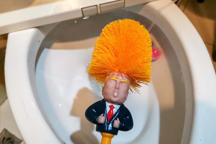 A local resident shows off a toilet brush that features U.S. president Donald Trump at his home in Shanghai, May 15, 2019. IC