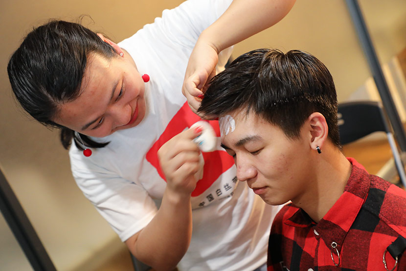 A volunteer applies makeup on one of the actors before the play “The Penis Monologues” in Hangzhou, Zhejiang province, May 18, 2019. Courtesy of White Ribbon’s Hangzhou branch