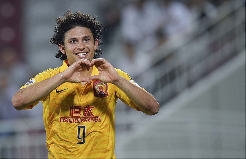Brazilian soccer player Elkeson makes a heart sign to fans during an AFC Champions League match in Doha, Qatar, Sept. 18, 2013. VCG