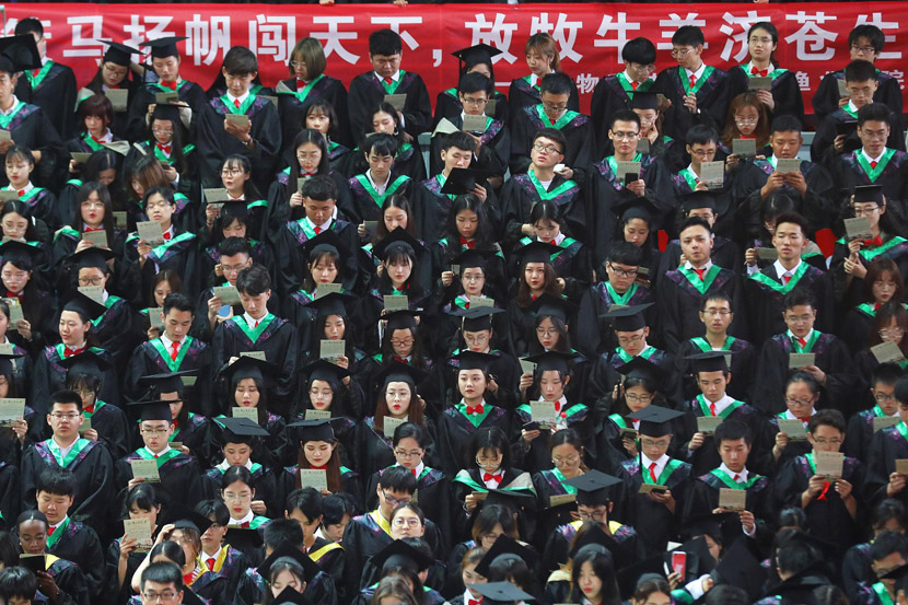 College students wait to sing during a performance of a school song at a graduation ceremony at Nanjing Agricultural University in Nanjing, Jiangsu province, June 20, 2019. Yang Bo/CNS/VCG