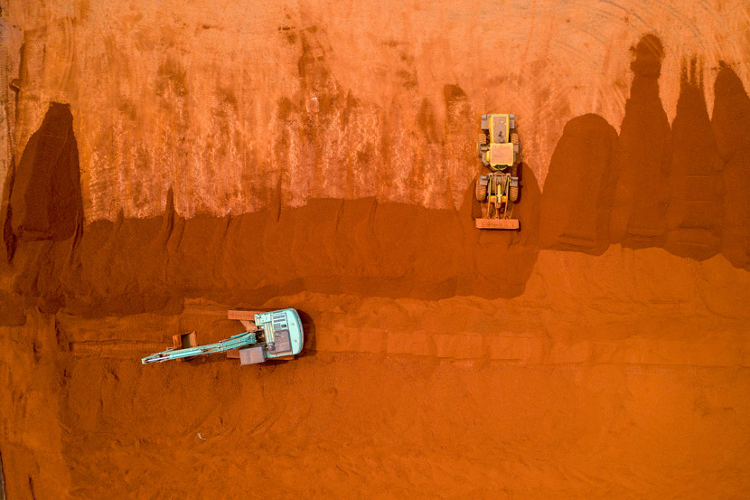 An aerial photograph shows vehicles loading and transporting aluminous soil imported from Guinea at Binzhou Port in Binzhou, Shandong province, June 19, 2019. Fu Kun/VCG