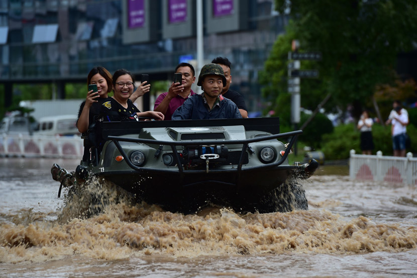 A rescue worker transfers people in an amphibious vehicle during a flood caused by heavy rain in Yiwu, Zhejiang province, June 21, 2019. IC