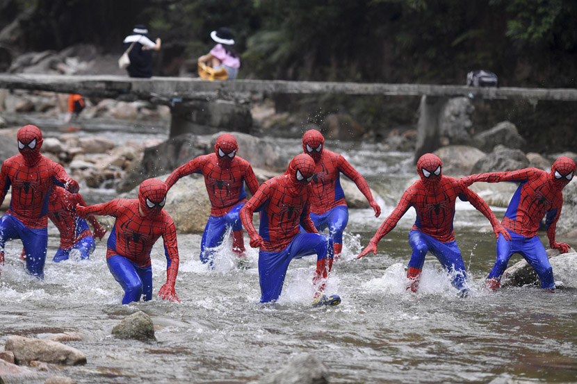 People dressed in Spider-Man suits run through a river during a race held at the Jiulong River National Forest Park in Chenzhou, Hunan province, July 4, 2019. Yang Huafeng/CNS/VCG