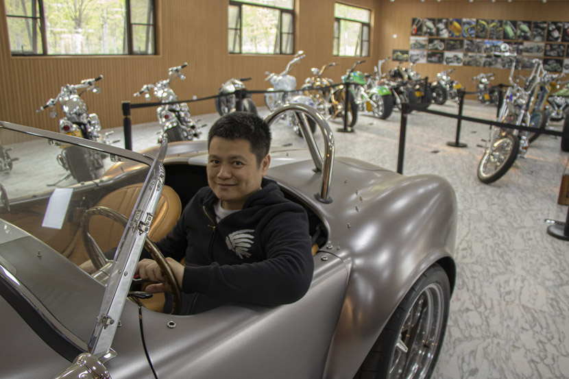 Zhang Xiaolei poses in a silver Shelby Cobra at Songsan Motors’ Museum of Premium Vehicles in Beijing, April 22, 2019. Kenrick Davis/Sixth Tone
