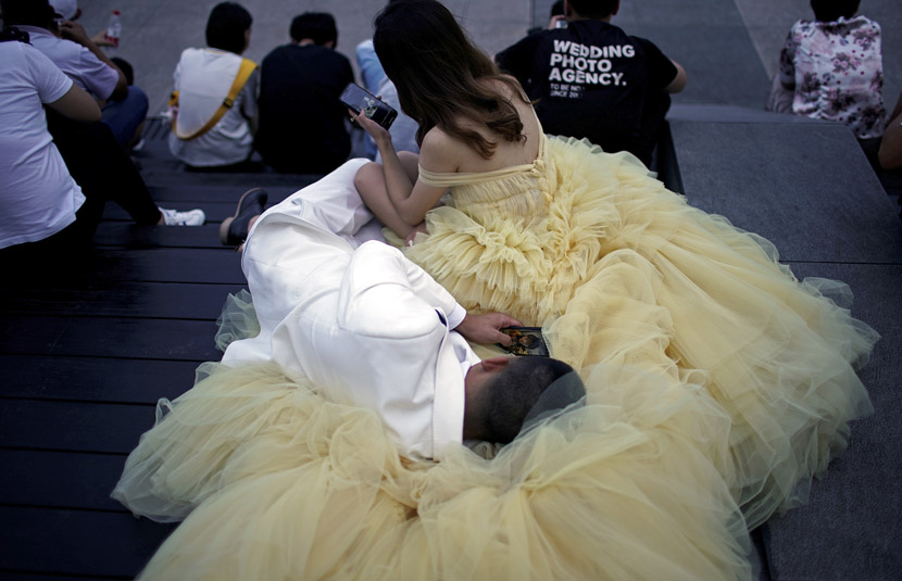 A couple rest during their wedding photo shoot in the riverfront Bund area in Shanghai, July 19, 2019. Aly Song/Reuters/VCG
