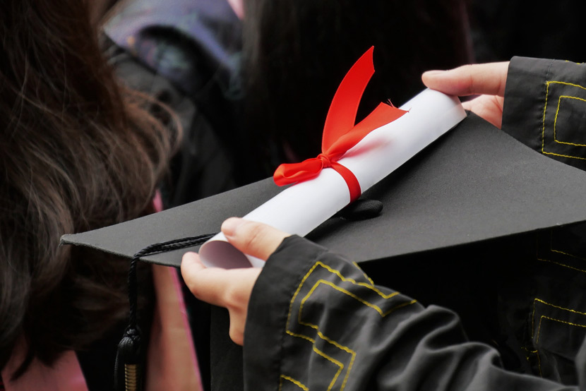 A university graduate holds their certificate during a graduation ceremony in Guangzhou, Guangdong province, May 26, 2019. Li Zhihao/VCG