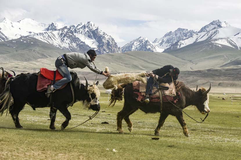Two Kazakh men scramble for a sheep during a traditional horseback game in Taxkorgan County, Xinjiang Uygur Autonomous Region, July 9, 2019. Zhang Hui/VCG
