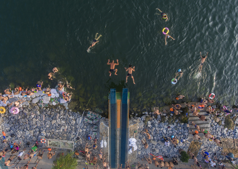 An aerial view of swimmers diving into the Han River to escape the summer heat in Xiangyang, Hubei province, July 22, 2019. Yang Dong/VCG