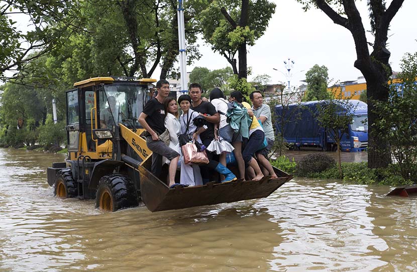 A bulldozer transfers people trapped by rising waters from the Lijiang River in Guilin, Guangxi Zhuang Autonomous Region, July 13, 2019. Hu Peng/VCG