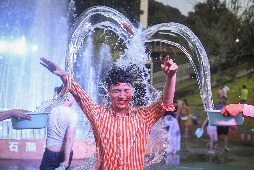 A man is doused with water during a community event in Changsha, Hunan province, July 31, 2019. Yang Huafeng/CNS/VCG