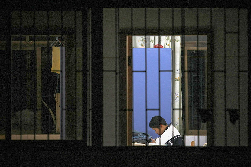 A teenage boy does his homework in a welfare home in Shenzhen, Guangdong province, Jan. 1, 2010. Zhao Yanxiong/Southern Metropolis Daily/VCG