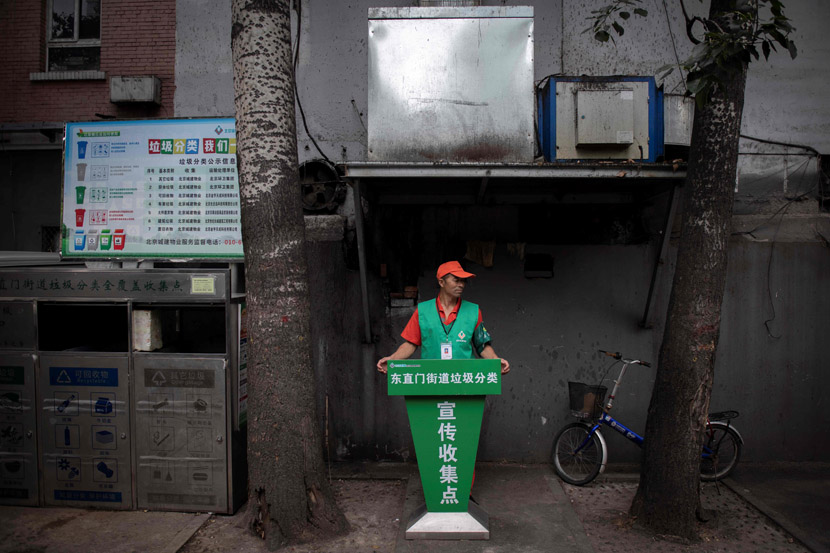 A neighborhood worker supervises a compulsory waste-sorting site in Beijing, Aug. 14, 2019. Nicolas Asfouri/AFP/VCG