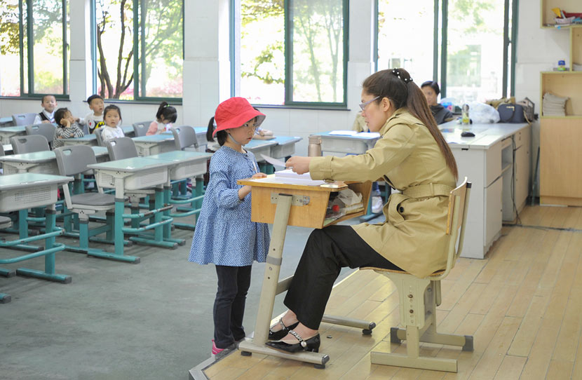 A girl talks to a teacher during an interview for a private school’s enrollment in Hangzhou, Zhejiang province, April 15, 2017. VCG