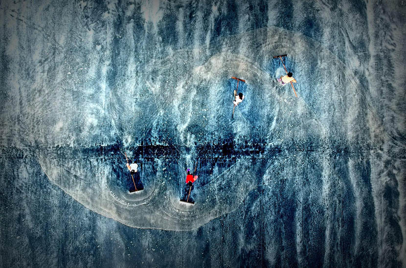 An aerial view of laborers drying salt at a salt pond in Putian, Fujian province, Aug. 23, 2019. Lü Ming/China News Service/VCG