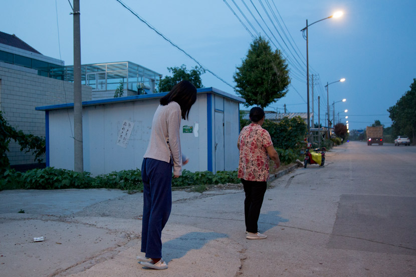 Zhao Yangyang and her grandmother stand on a road in front of their house in Sheyang, Jiangsu province, July 29, 2019. Shi Yangkun/Sixth Tone