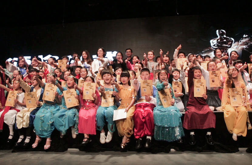 Children and teachers pose for a photo at Huangpu Theater in Shanghai, May 28, 2017. Liu Jingwen/Sixth Tone
