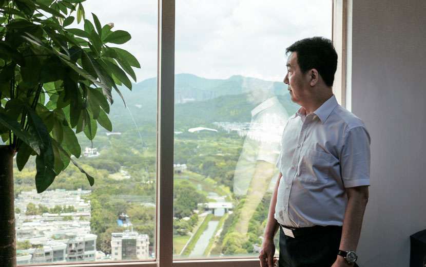 Lin Feng looks out the window of his office in Shenzhen, Guangdong province, June 9, 2017. Cai Yiwen/Sixth Tone
