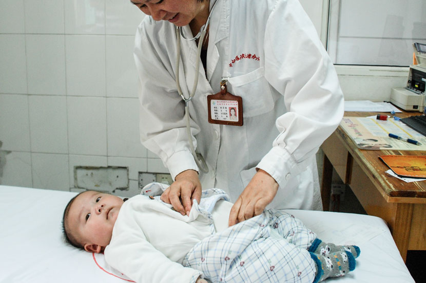 A pediatrician performs a checkup on a young patient at Zhongshan Hospital in Shanghai, March 21, 2006. Courtesy of Xu Lingmin