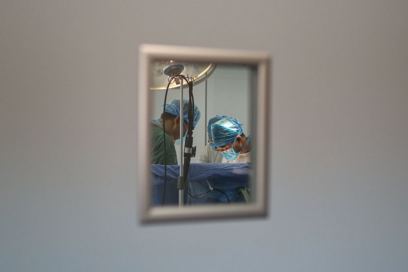 Medical staff operate on a patient at a hospital in Jinan, Shandong province, June 14, 2014. Quan Yi/Sixth Tone