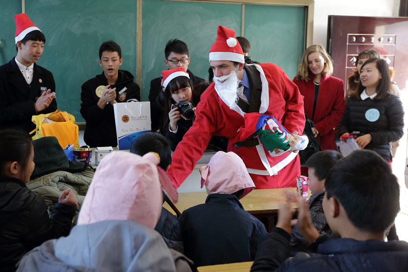 A foreign teacher dresses up as Santa Claus for a Christmas-themed lesson at an international school in Zhuji, Zhejiang province, Dec. 23, 2014. Luo Shanxin/IC