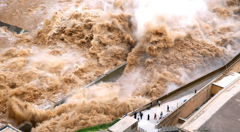 People watch the water released by the Sanmenxia Dam, constructed to prevent floods in Sanmenxia, Henan Province, Aug. 28, 2019. Sun Meng/IC