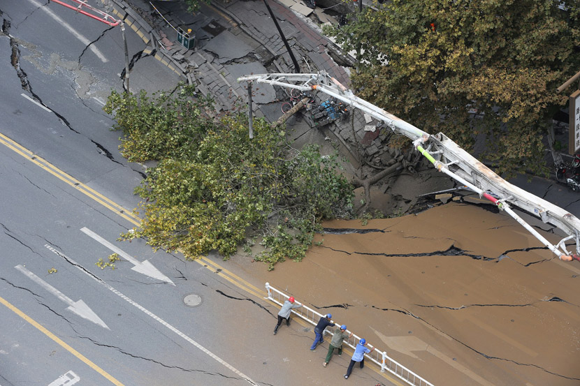 Cement is being poured into the subsided section of a road in Hangzhou, Zhejiang province, Aug. 28, 2019. A subway line runs under the cave-in, and residents in the nearby 13 buildings have been evacuated as assessments and reconstructions are underway. Chen Zhongqiu/VCG