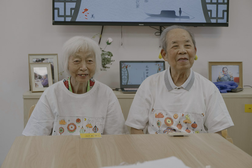 Dementia patients Liu Yunshu (left) and Yu Jinliang (right) wear the T-shirts they made at the event in Shanghai, Sept. 12, 2019. Zhu Yuqing/Sixth Tone
