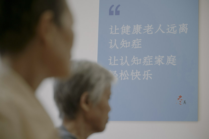 A poster on the wall of the events room reads, “Help healthy old people stay away from dementia; help the dementia families find relaxation and happiness.” Photo taken in Shanghai, Sept. 17, 2019. Zhu Yuqing/Sixth Tone