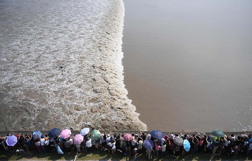 Tourists watch the tide roll in along the Qiantang River in Jiaxing, Zhejiang province, Sept. 17, 2019. Wang Gang/CNS/VCG