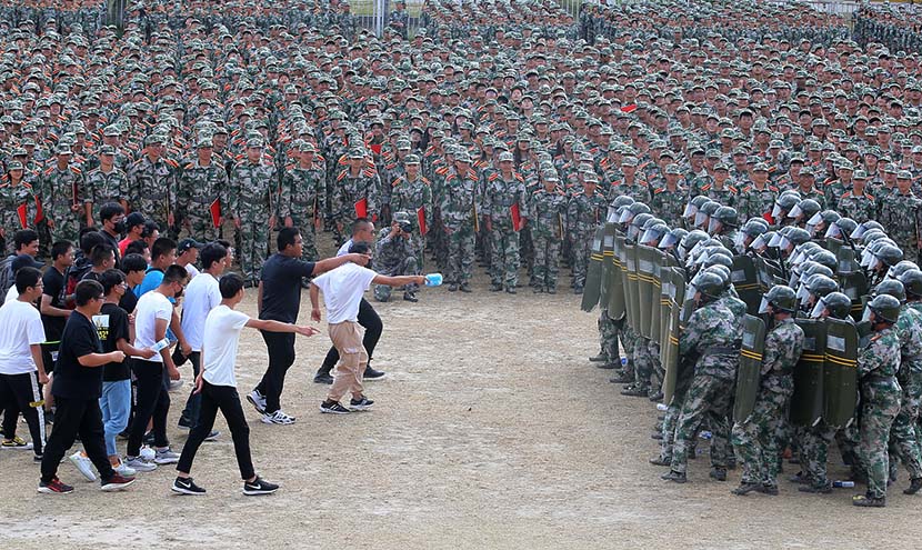 Freshmen students at Nantong Vocational College show off their riot response skills at the conclusion of their mandatory military training in Nantong, Jiangsu province, Sept. 20, 2019. Xu Peiqin/VCG