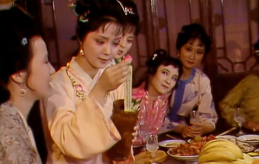 A screenshot from the 1987 TV series “Dream of the Red Chamber” shows Xue Baochai picking a peony-related poem out of a vase. From CCTV电视剧 on YouTube