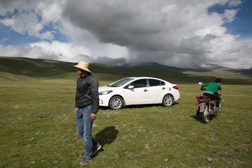 Ma Jingui (left) and his son drive their cattle and sheep to their winter pastures in Qilian County, Qinghai province, July 2019. Shi Yangkun/Sixth Tone
