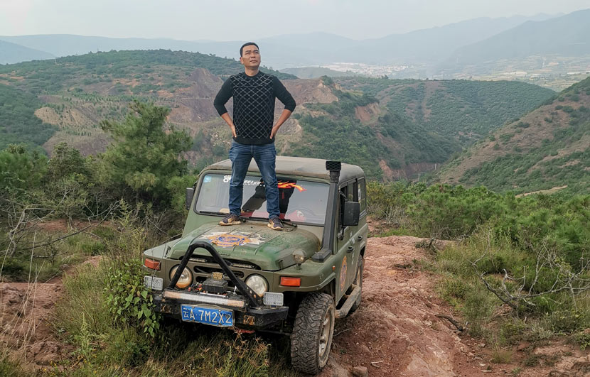 Gao Chunyan poses for a photo on the hood of his “Beijing Jeep” in a rural area in Yunnan province, Sept. 25, 2019. Courtesy of Gao Chunyan