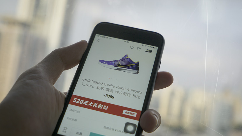 A user checks the price of a pair of Nike Kobe 4 Protros on the app Poizon. Sixth Tone