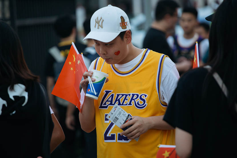 A fan takes a sip before an NBA preseason game between the Brooklyn Nets and the Los Angeles Lakers at Mercedes-Benz Arena in Shanghai, Oct. 9, 2019. The game drew international attention amid a nationalist backlash to a tweet sent by Houston Rockets general manager Daryl Morey. Wu Huiyuan/Sixth Tone