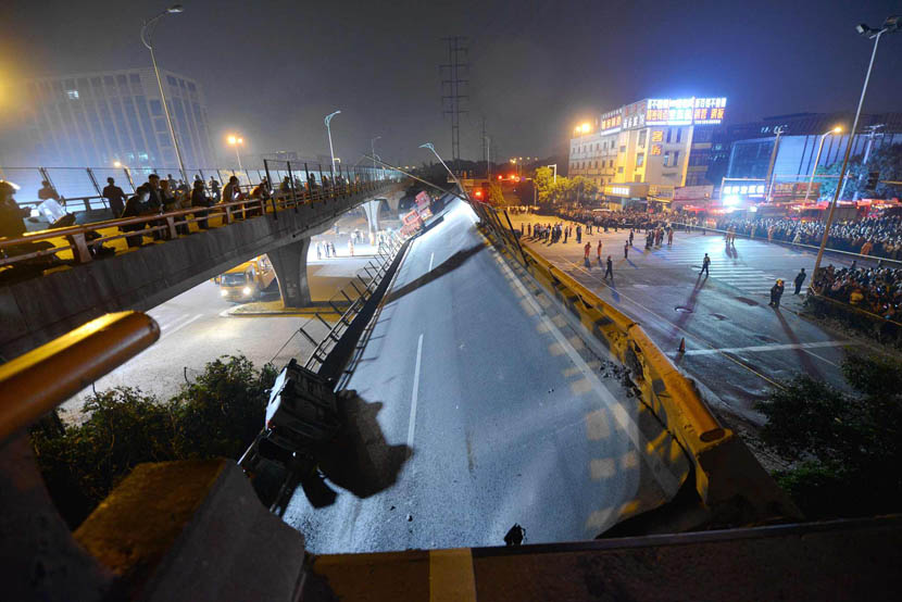 Local residents look at a collapsed overpass in Wuxi, Jiangsu province, Oct. 10, 2019. Three people were killed when the cars they were in were crushed by falling debris, according to local authorities. Yang Mujun/VCG