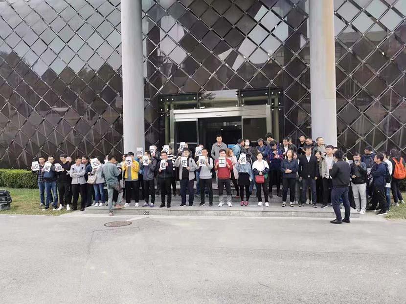 Current and former employees of solar energy firm Hanergy Thin Film Power Group Limited stand in front of the company’s headquarters during a three-day protest over unpaid wages. From The Paper