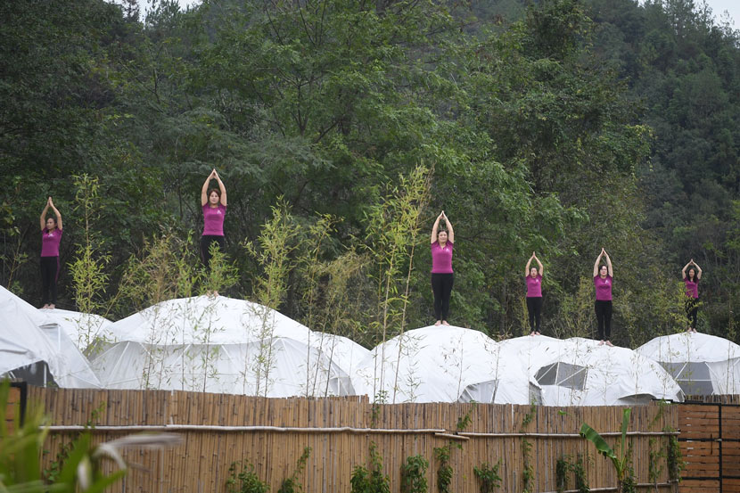 Women participate in a yoga show atop safari tents at Donghuzhai Scenic Area in Jiujiang, Jiangxi province, Oct. 15, 2019. VCG